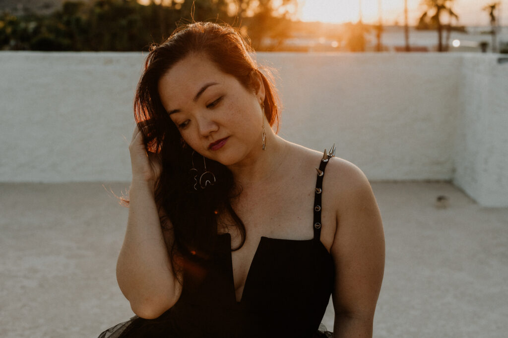 Sunset portrait on Arizona roof top. Girl wearing black dress with spikes